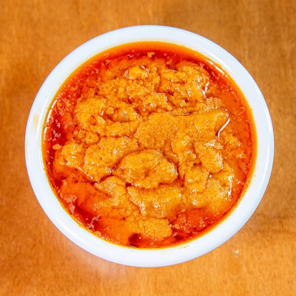 Overhead view of a white bowl filled with orange-red Ethiopian Shiro Wot stew.